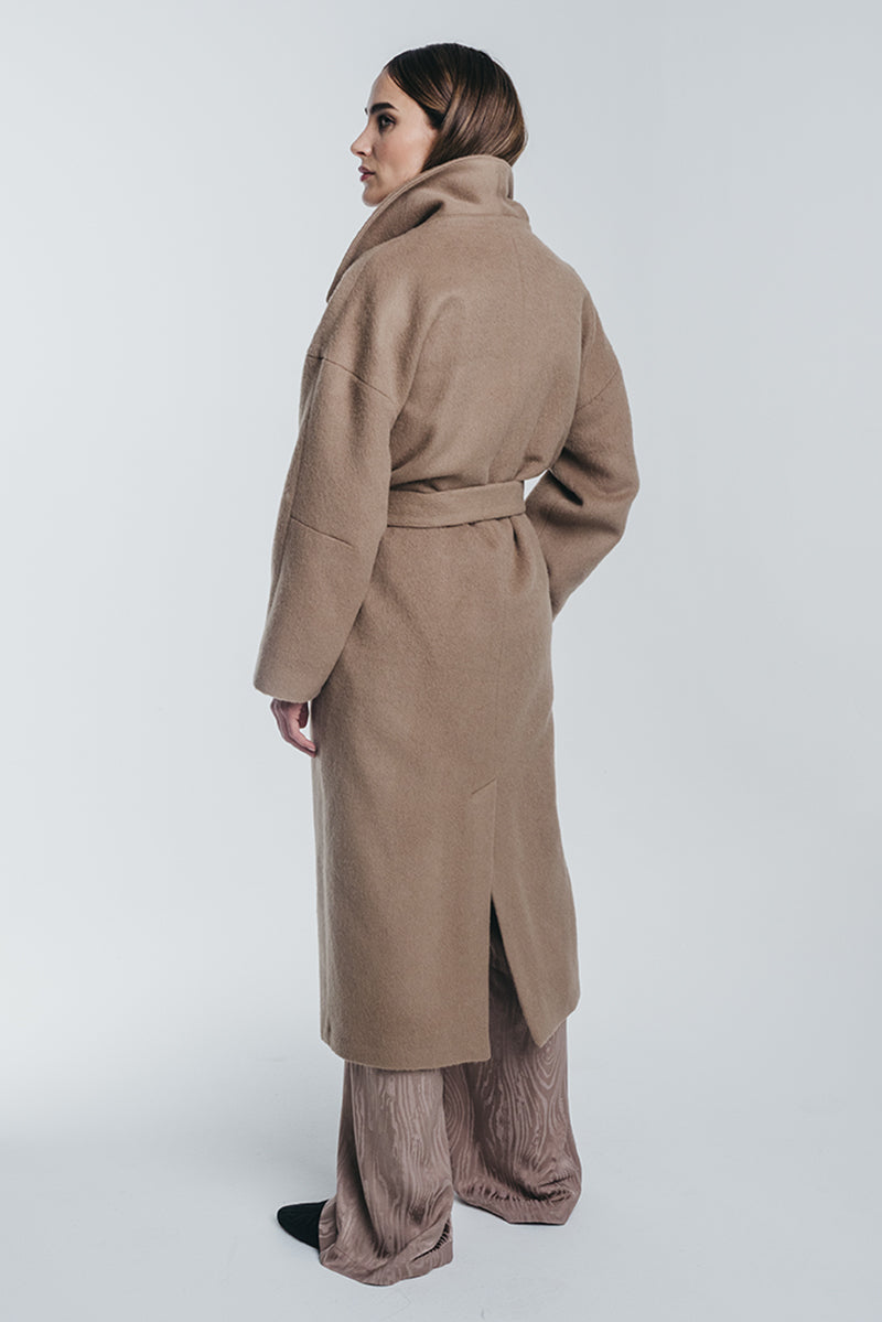 Kaamos long coat in camel tied with matching belt. Made of alpaca and virgin wool.  Back picture. Hálo from north