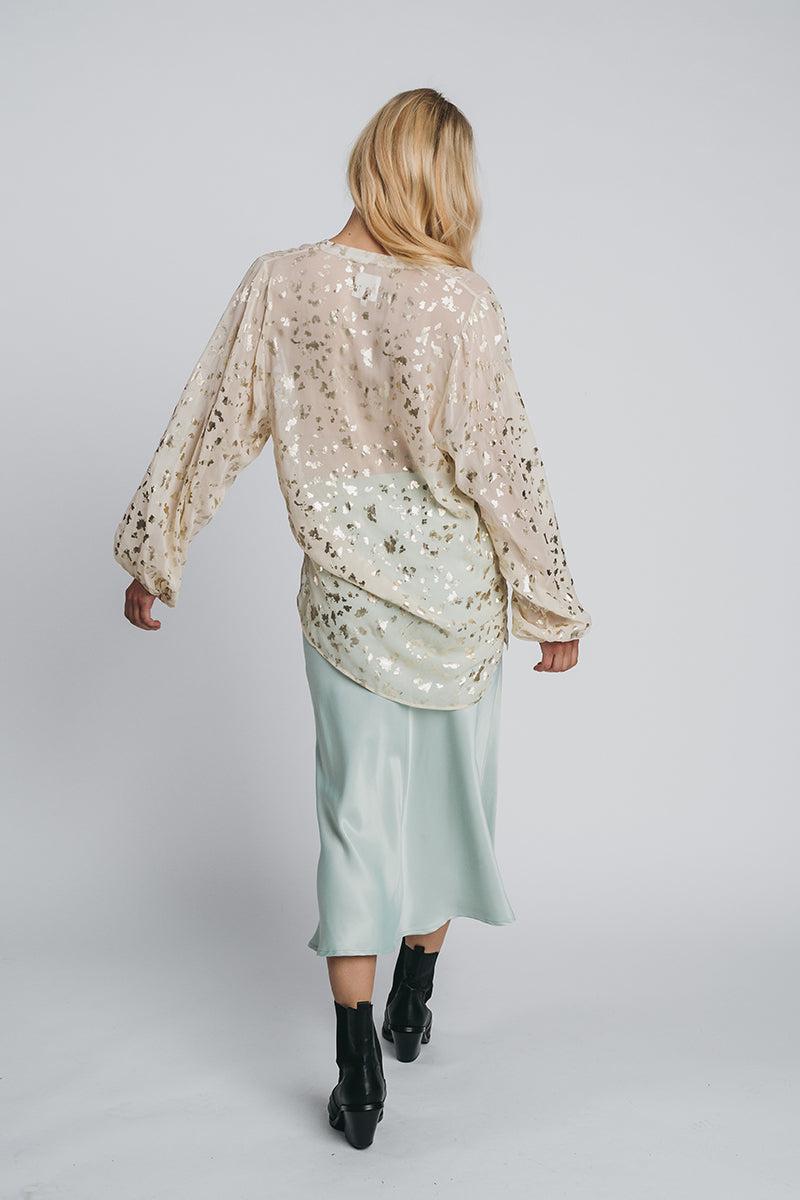 Petronella chiffon blouse paired with kajo slip skirt in misty green. Picture from the behind. Hálo from north